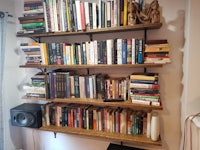 a shelf full of books and a speaker in a room